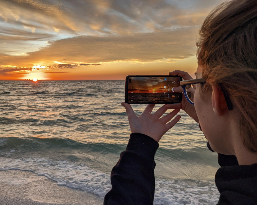 Traveler taking photo with camera at sunset over famous landmark