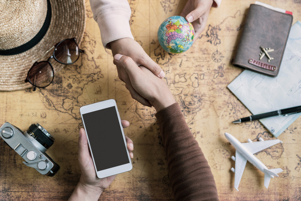 Book with a trusted agency Travel agent helping clients with laptop, flight and hotel confirmations visible
