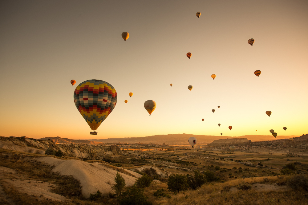 Turkiye in September Hot air balloons over Cappadocia's fairy chimneys in golden light