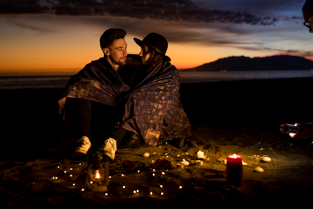 A private beach dinner setup at dusk in the Philippines with lanterns, candles, and two place settings overlooking the ocean