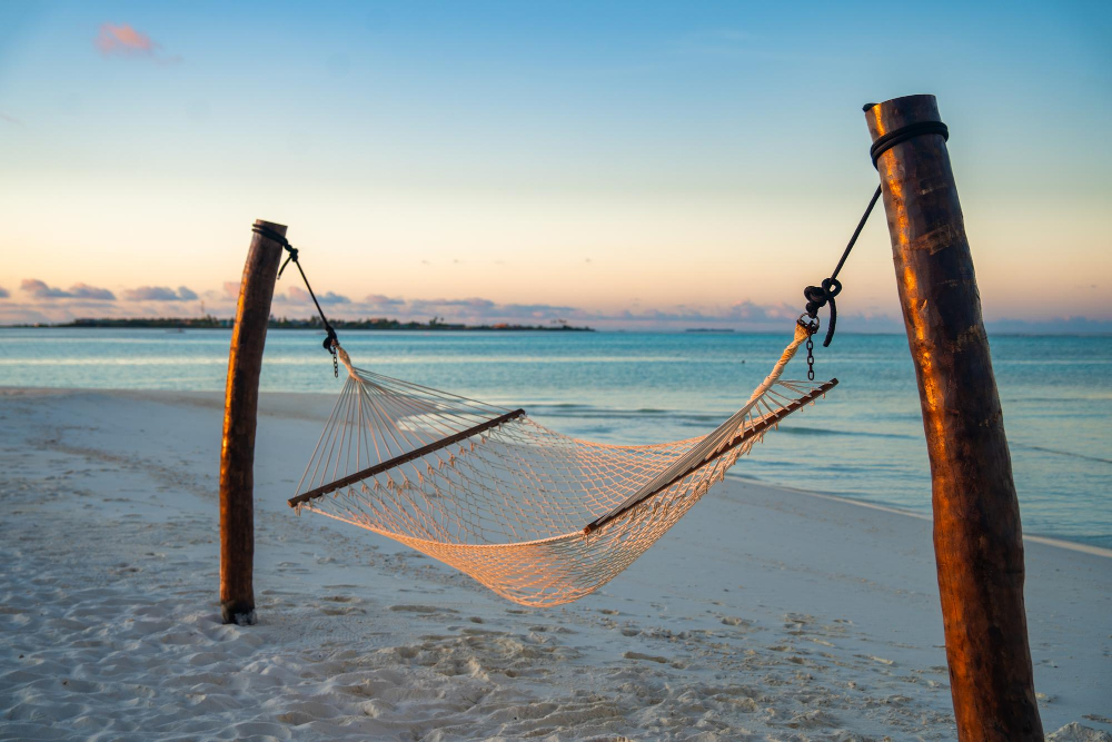 Beach Casita at Amanpulo Pamalican Island, private sundeck with hammock above white sand at dawn