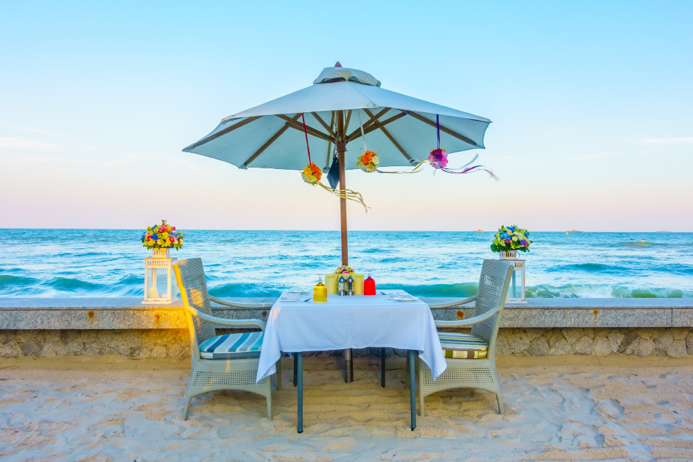 Couple having candlelight dinner on a private beach