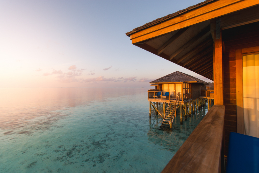 Maldives in September Overwater villa in Maldives with turquoise lagoon and sunset