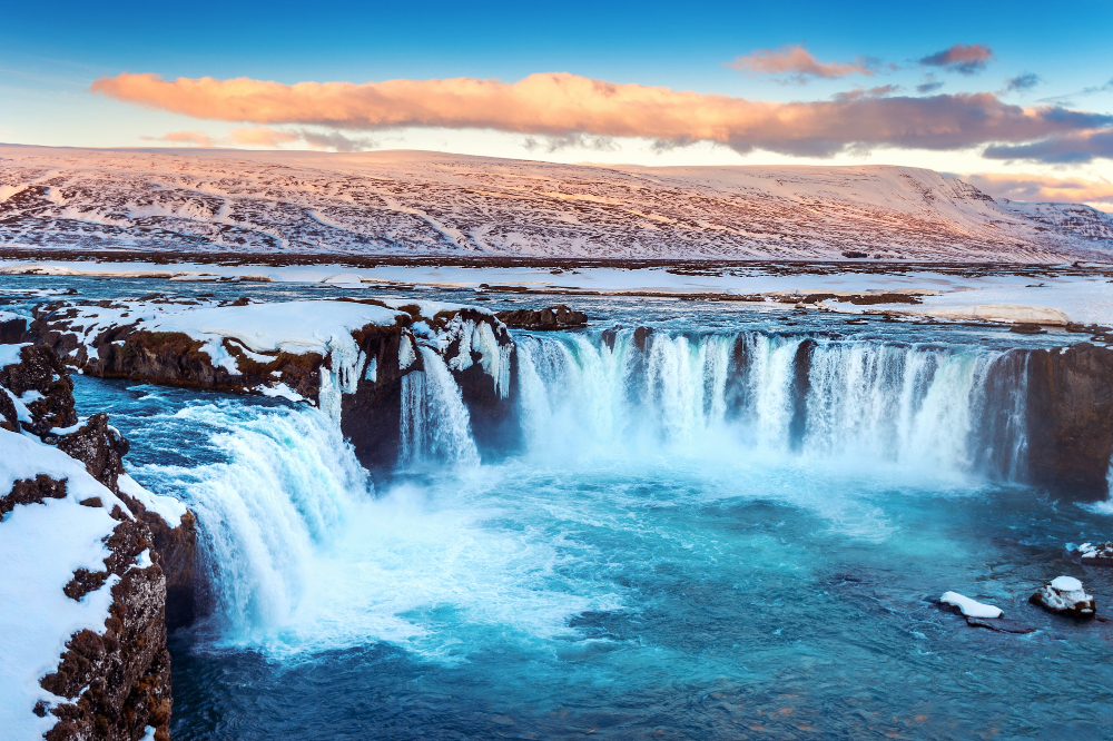 Iceland midnight sun Waterfall and green landscape under golden midnight sun in Iceland
