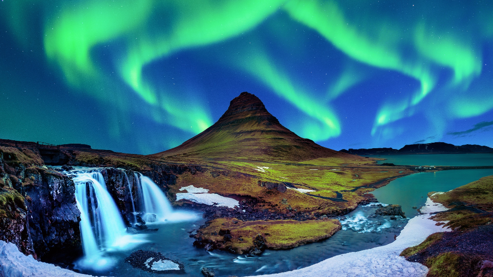 Green aurora borealis over a waterfall and night sky