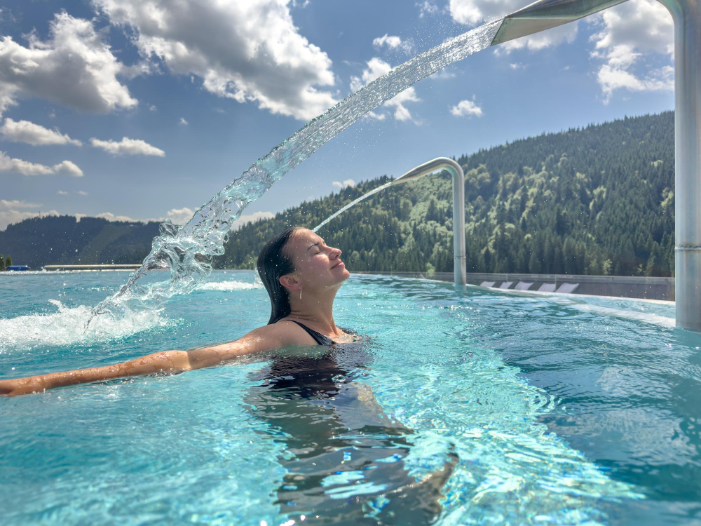 Private outdoor hydrotherapy pool overlooking Swiss Alpine valley at a luxury wellness retreat