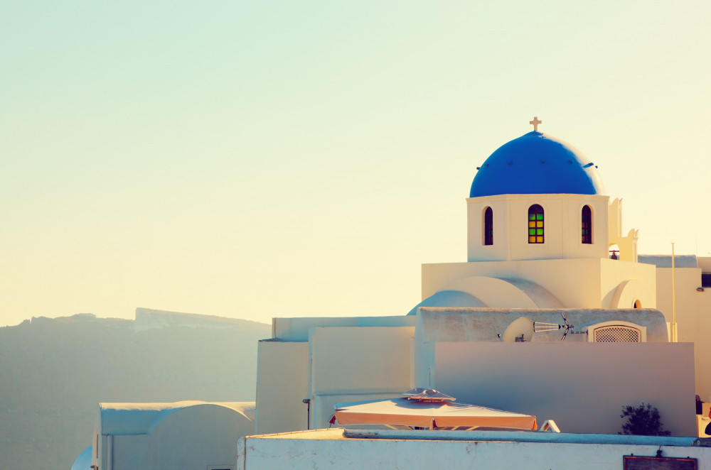Greek Islands in June White buildings with blue domes overlooking Aegean Sea in Santorini