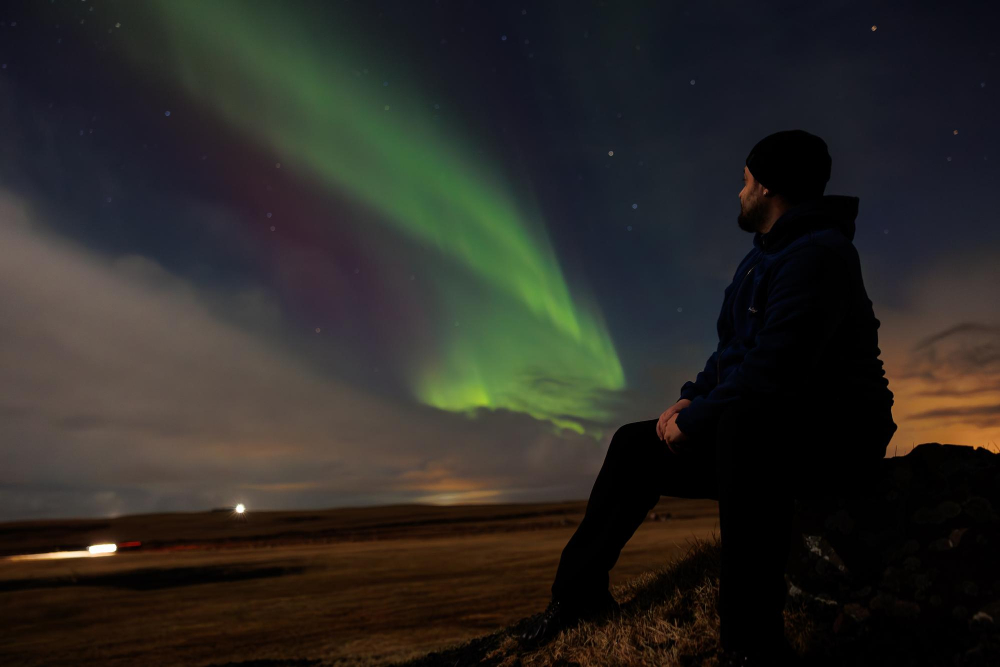 Green aurora borealis over snowy Icelandic landscape