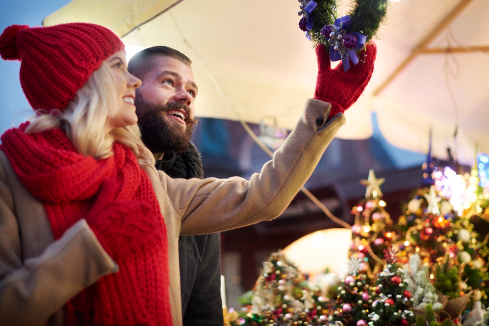 Christmas market with wooden stalls, lights and a snowy town square