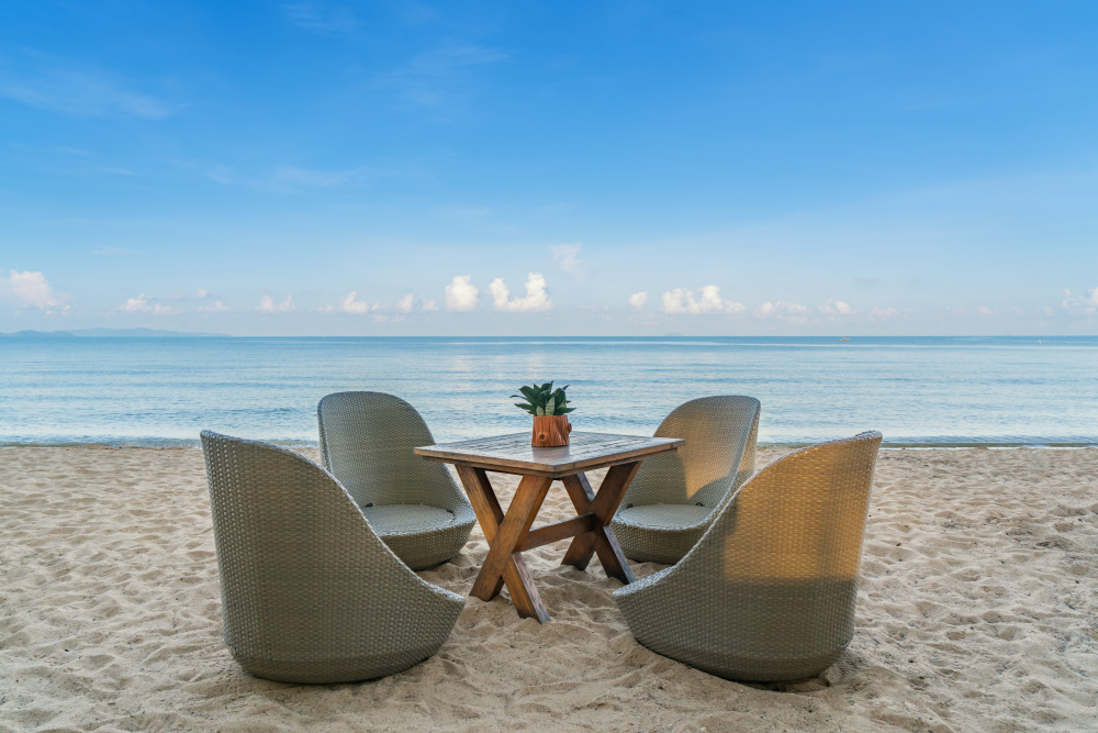 Private island dinner setup Private beach dinner table set for a group on an exclusive island at sunset