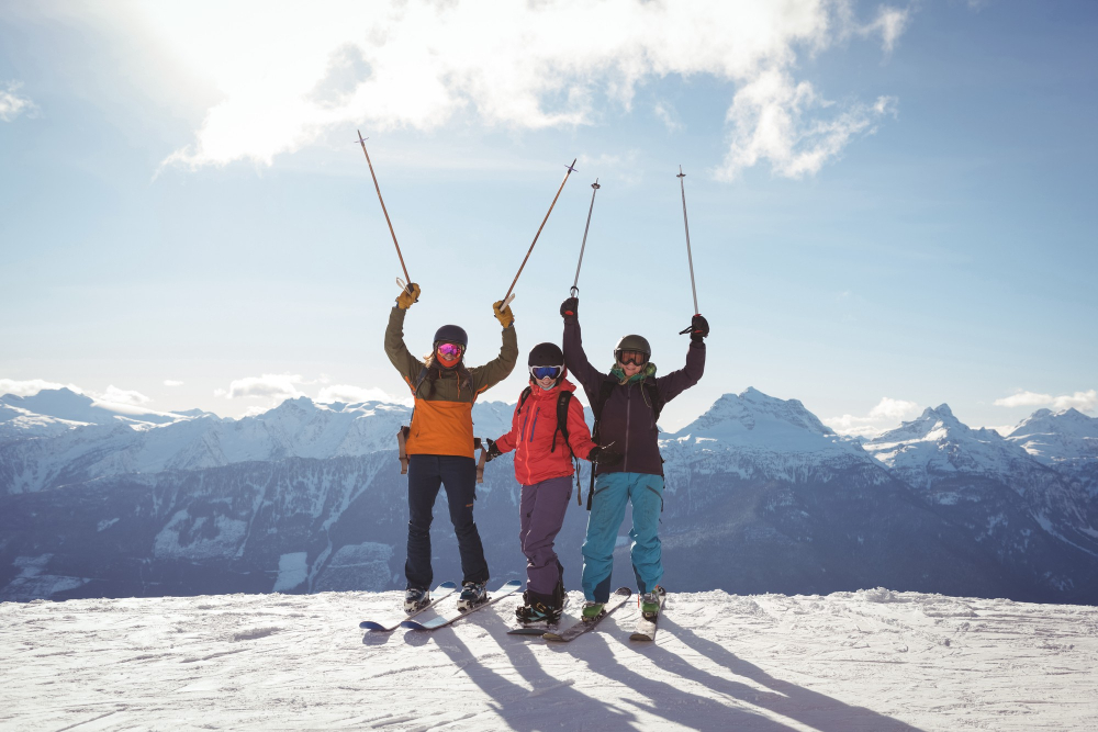 Late-season skiing in the Alps Skiers on a sunny alpine slope with snow-covered peaks